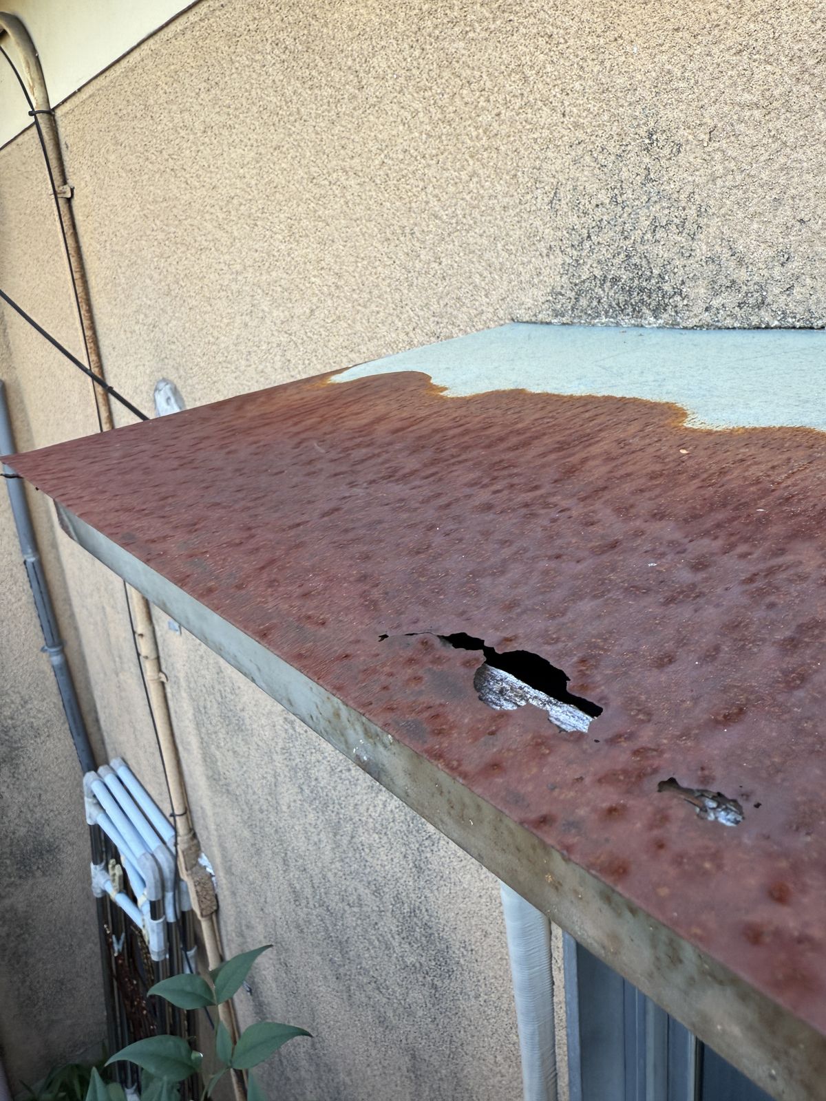 錆びて穴が開いた庇の板金